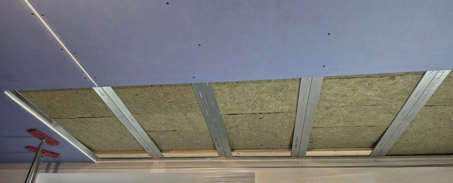 Freitragende Schallschutzdecke im Aufbau mit Metallprofilen und Mineralwolle
